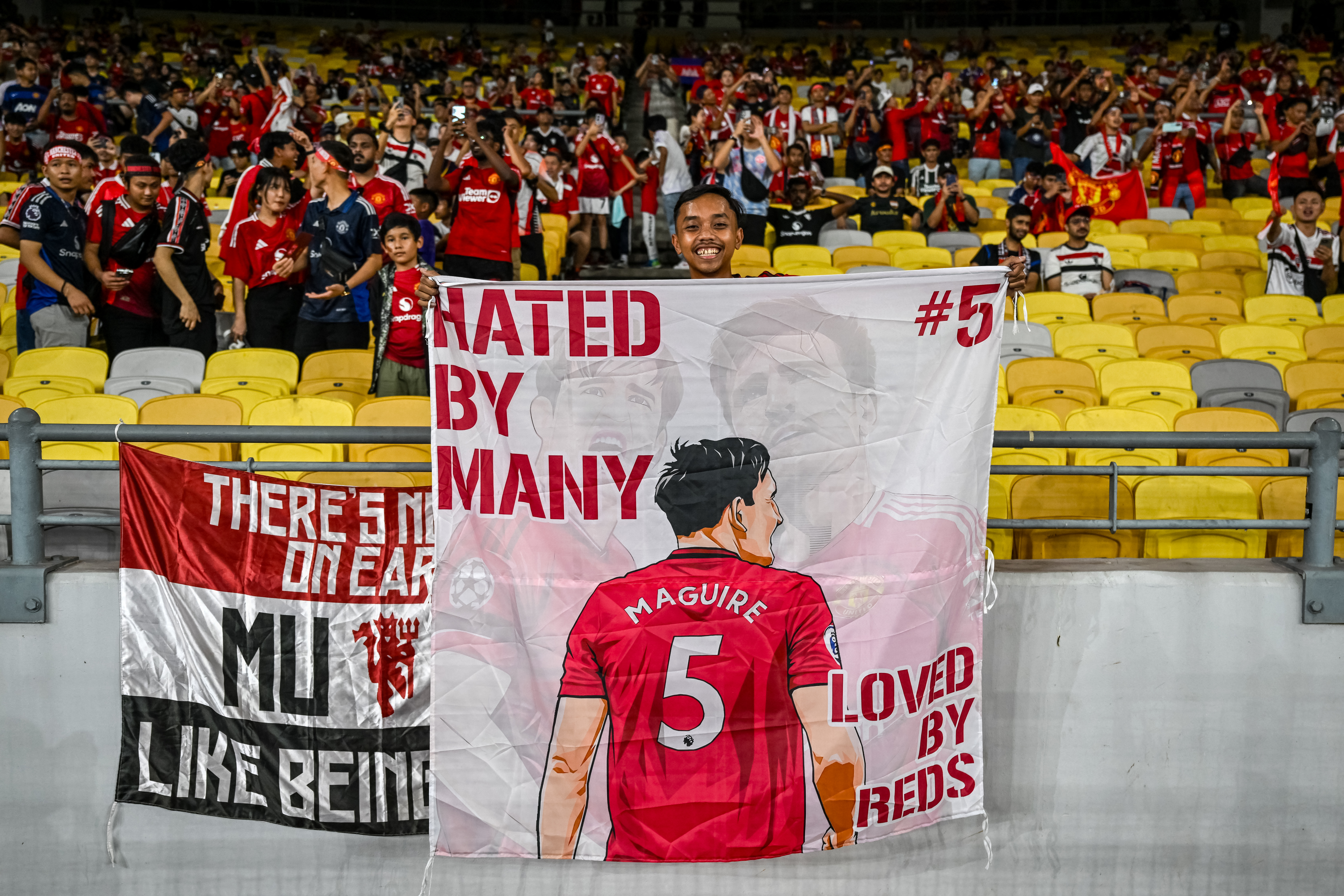 Fan holding a banner supporting Manchester United player Maguire.