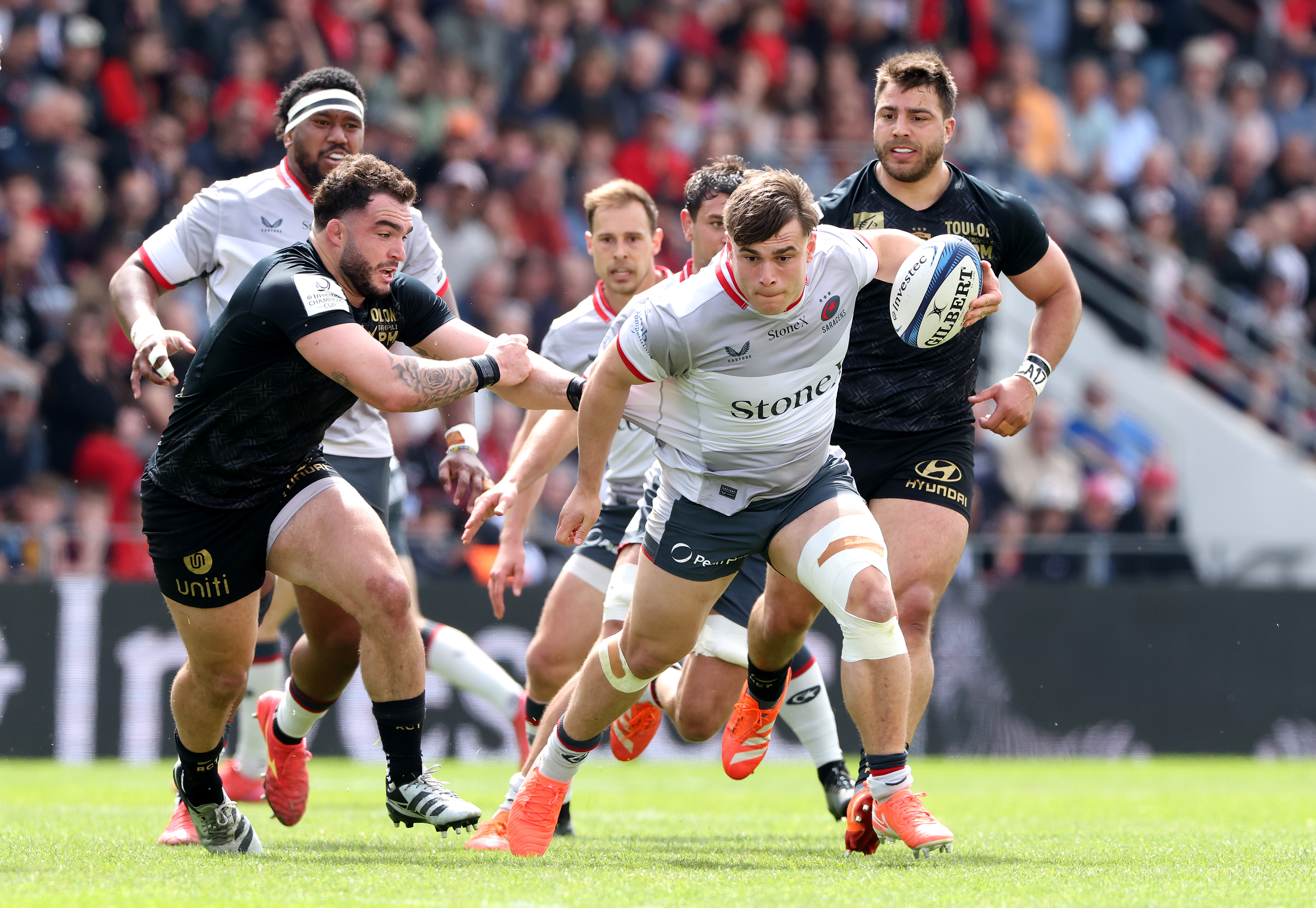 Rugby player running with the ball during a match.